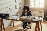 business owner at a desk determining her professional liability insurance cost